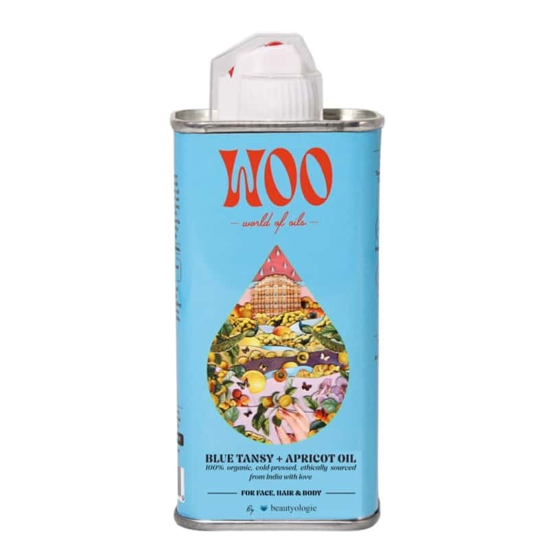 A metal can of Woo World of Skin Blue Tansy + Apricot Oil with a light blue label, featuring a white flip-top cap and a colorful teardrop illustration on the front.
