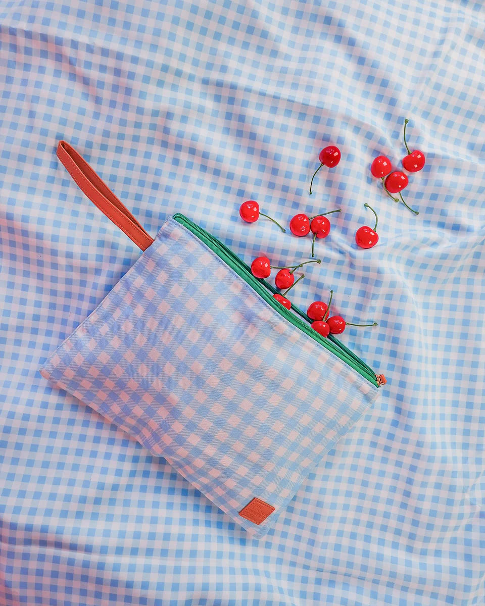 Blue checkered pouch with a pencil and cherries on a matching fabric background