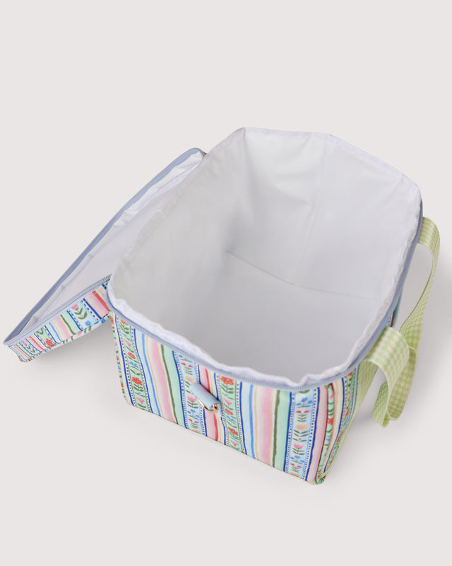 A rectangular insulated cooler bag with a colorful vertical stripe pattern on the exterior, a white interior lining, and a light green gingham fabric handle, shown open on a light beige background.