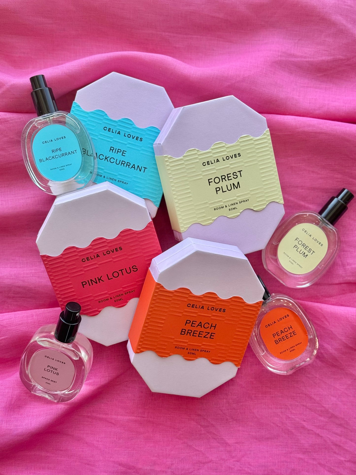 Celia Loves room spray packaging + bottles with pink background