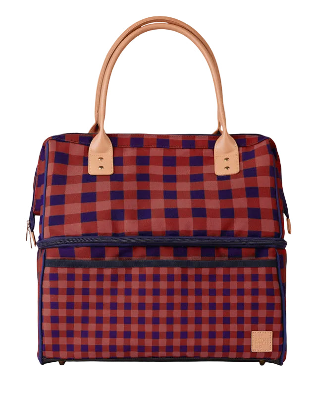 A structured tote bag with a red and navy blue buffalo plaid pattern, featuring tan leather handles and trim, set against a light gray background.