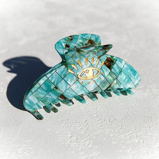 Green claw clip in tortoise print with flecks of brown and gold eye detail. 