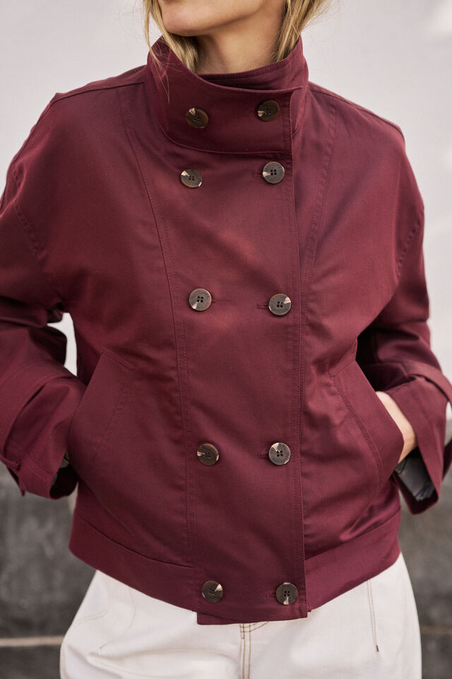 Maroon jacket with button details worn by a person against a neutral background