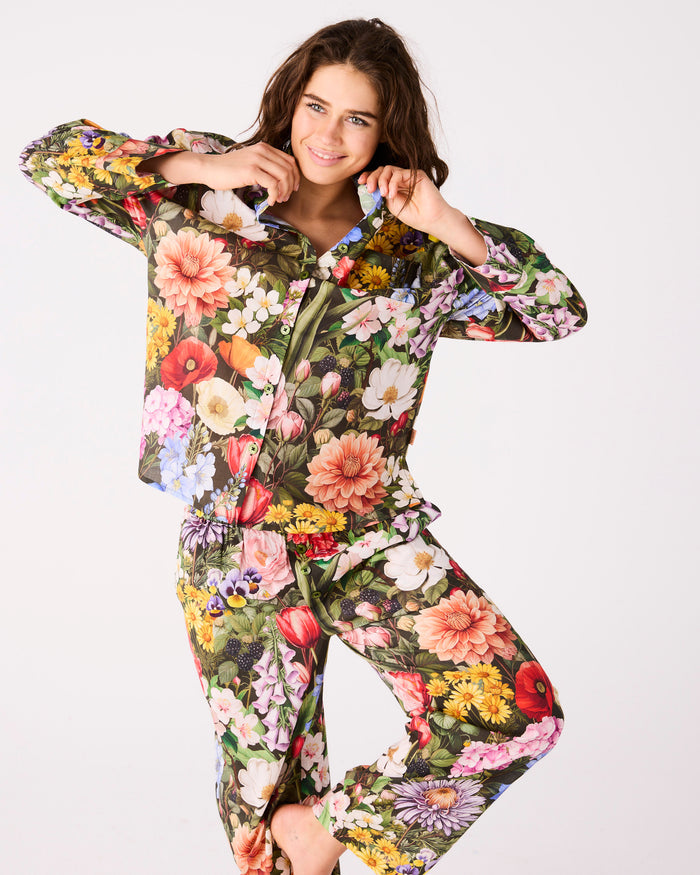 Woman wearing a colorful floral pj set on a white background