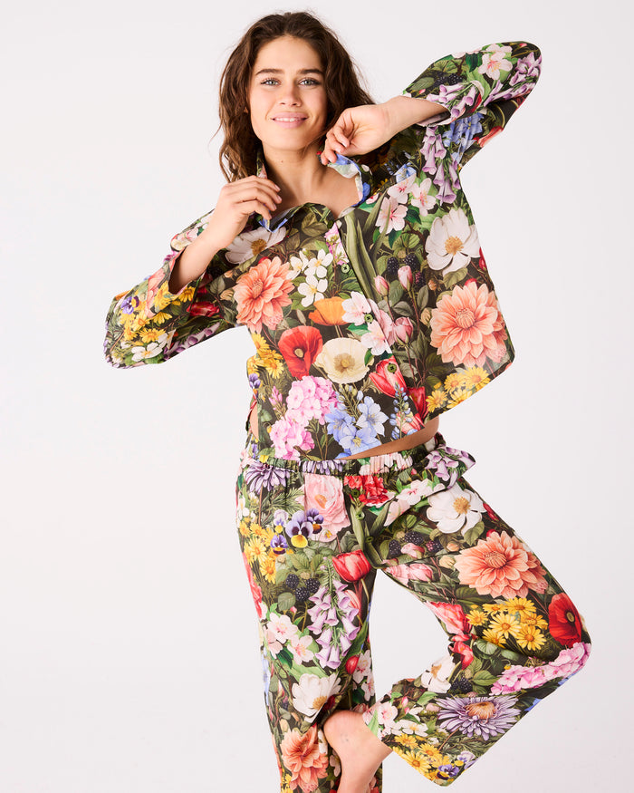 Woman wearing a colorful floral outfit on a white background