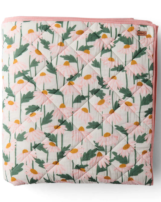 Floral patterned quilt with pink border on a white background