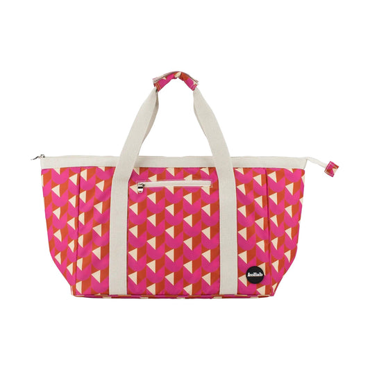 Tote bag with pink, orange and cream geo pattern and cream handles sits on white background.