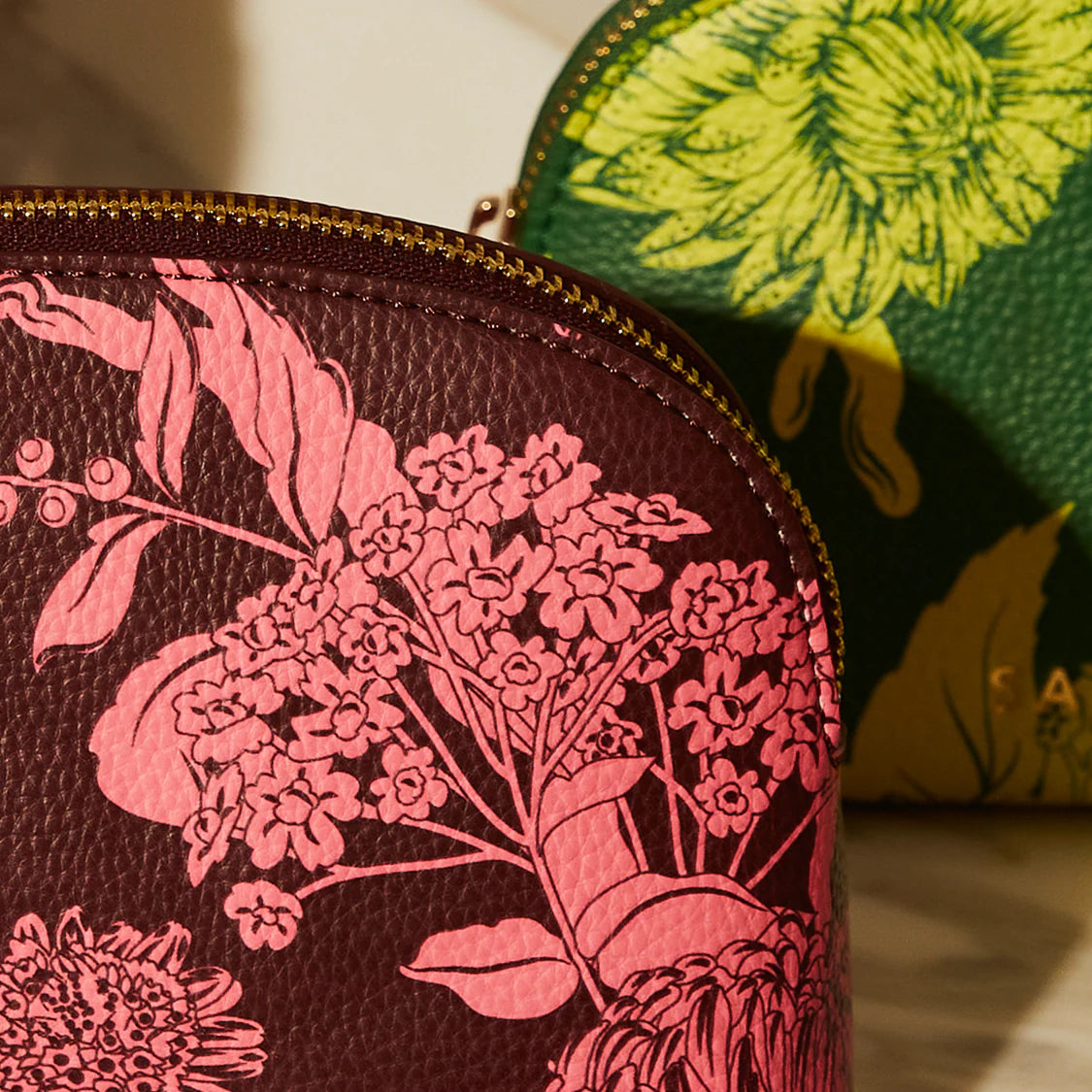 Close-up of a leather pouch with floral design, with another pouch in the background.