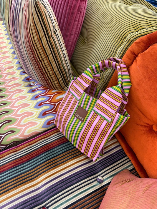 Petite bag splice sits on colourful stripe patterned cushions. 