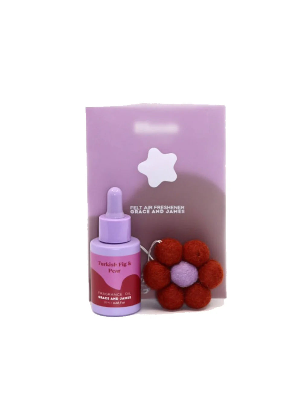 Purple bottle with dropper and felt flower air freshener with plastic packaging sitting behind on a white background.