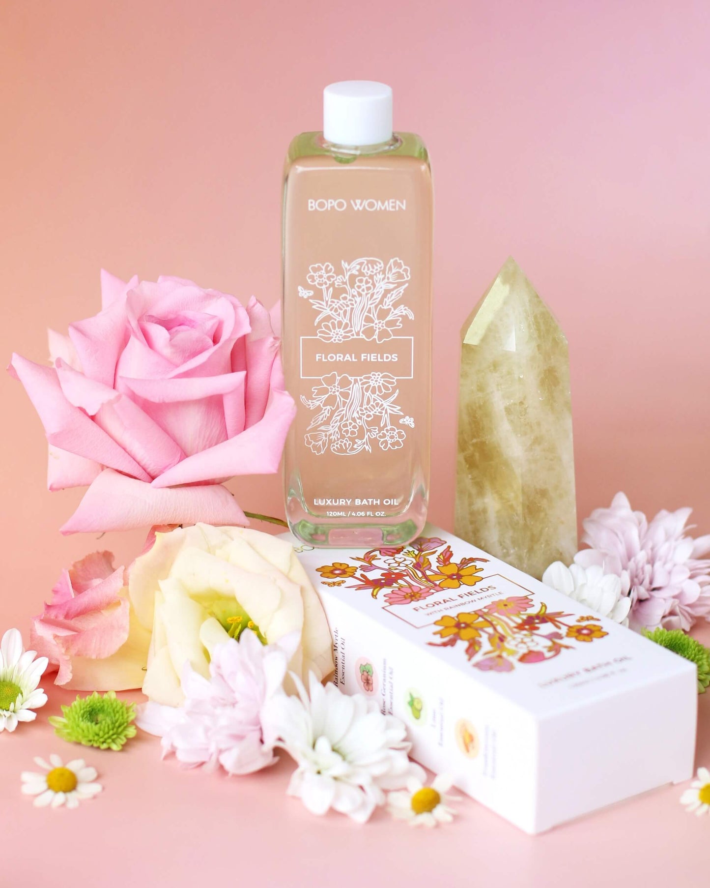 Bottle of floral body wash with pink rose and flowers on a pink background