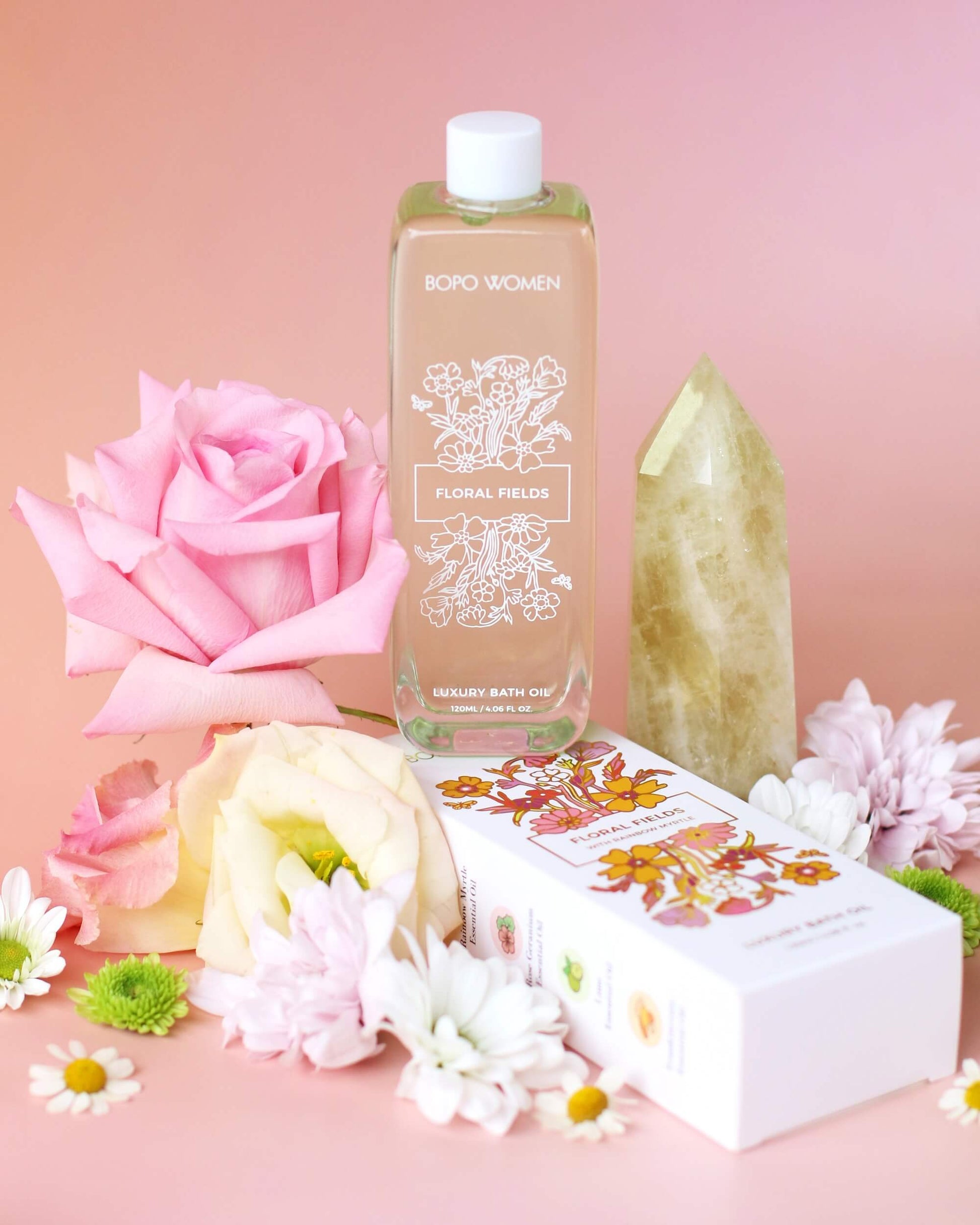 Bottle of floral body wash with pink rose and flowers on a pink background