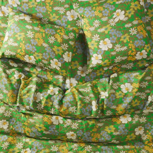 Close-up view of a green floral fitted sheet and matching pillowcases