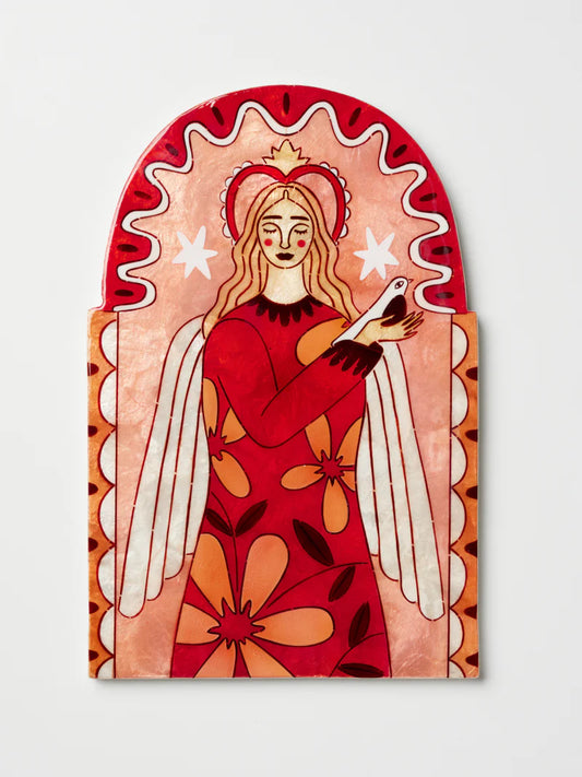 Decorative wall art of an angel with a red dress and white wings, holding a white dove, on a light gray background