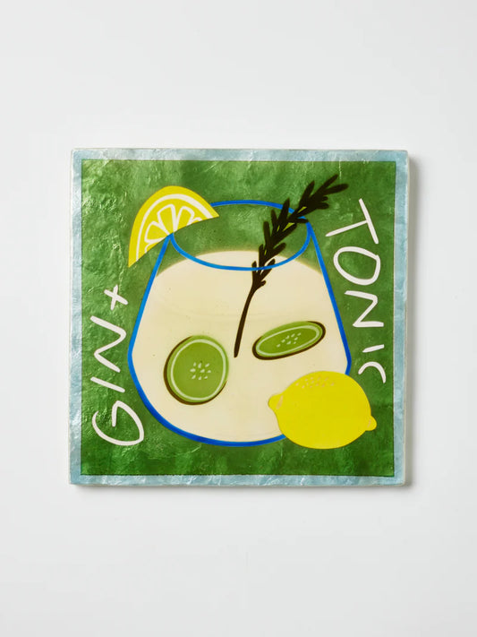Green square wall tile with blue glass pictured, lemon, and words gin + tonic.