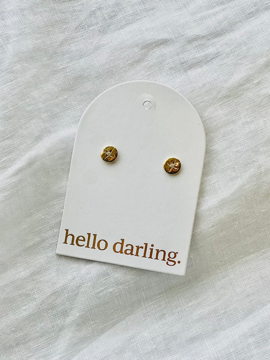 Gold circle earrings with a small crystal in centre of each earring on a 'hello darling' card against a white fabric background