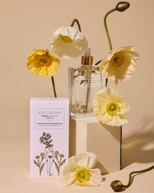 Boro Women perfume bottle with packaging and flowers on a beige background