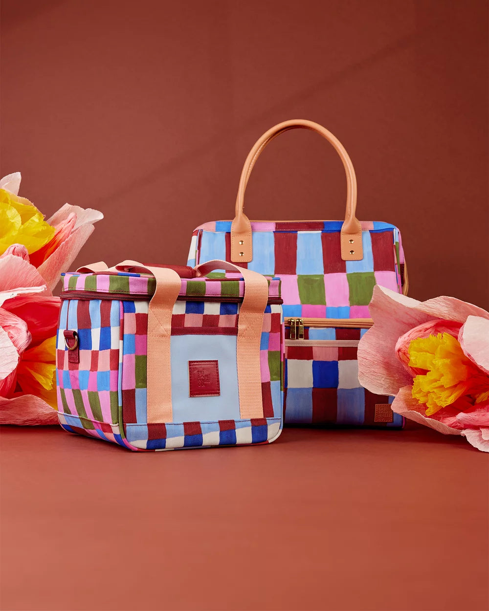 Colorful checkered handbag with a brown handle on a red background
