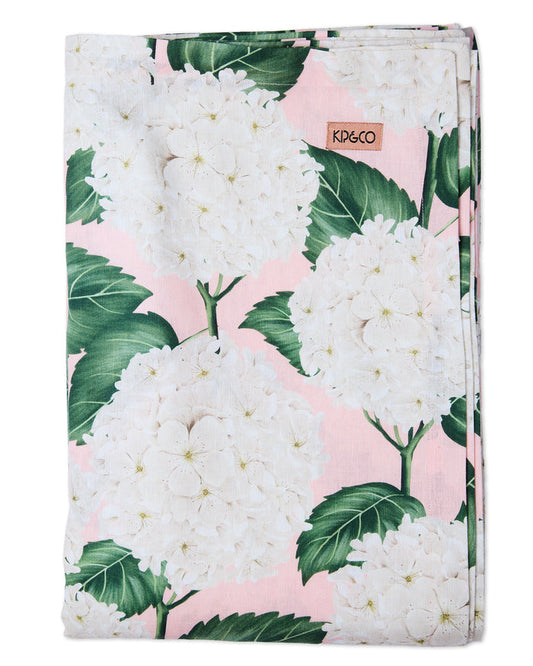 A folded baby blanket featuring a white and green hydrangea floral print on a light pink background, with a small tan K&DECO brand tag near the top.