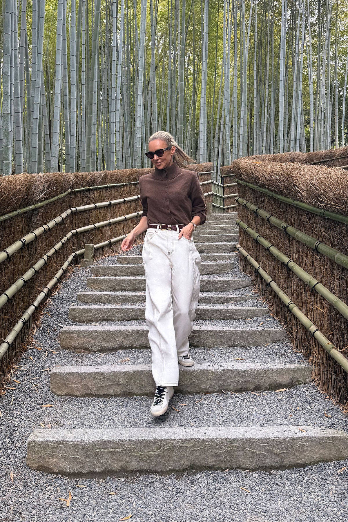 Man walking up a set of stairs in a bamboo forest