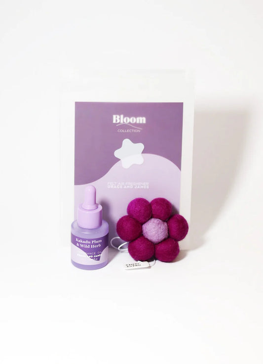Bloom product set with a bottle and fuchsia flower-shaped item on a white background