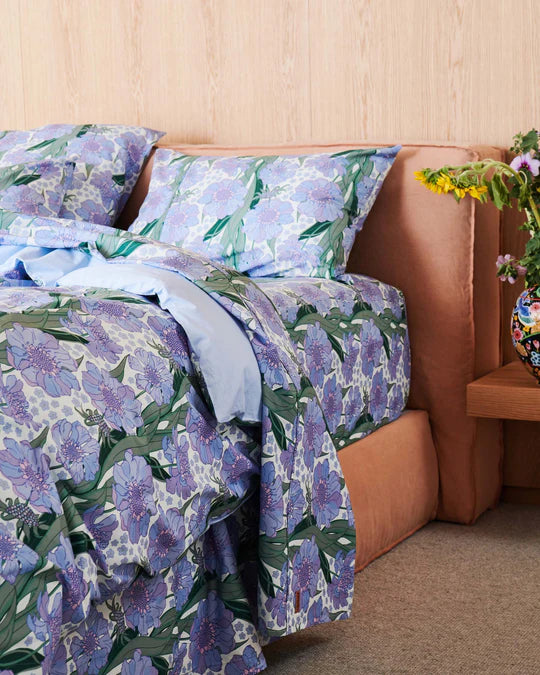 Bed with matching quilt cover, fitted sheet and pillowcases in blue floral print with large size flower pattern. 