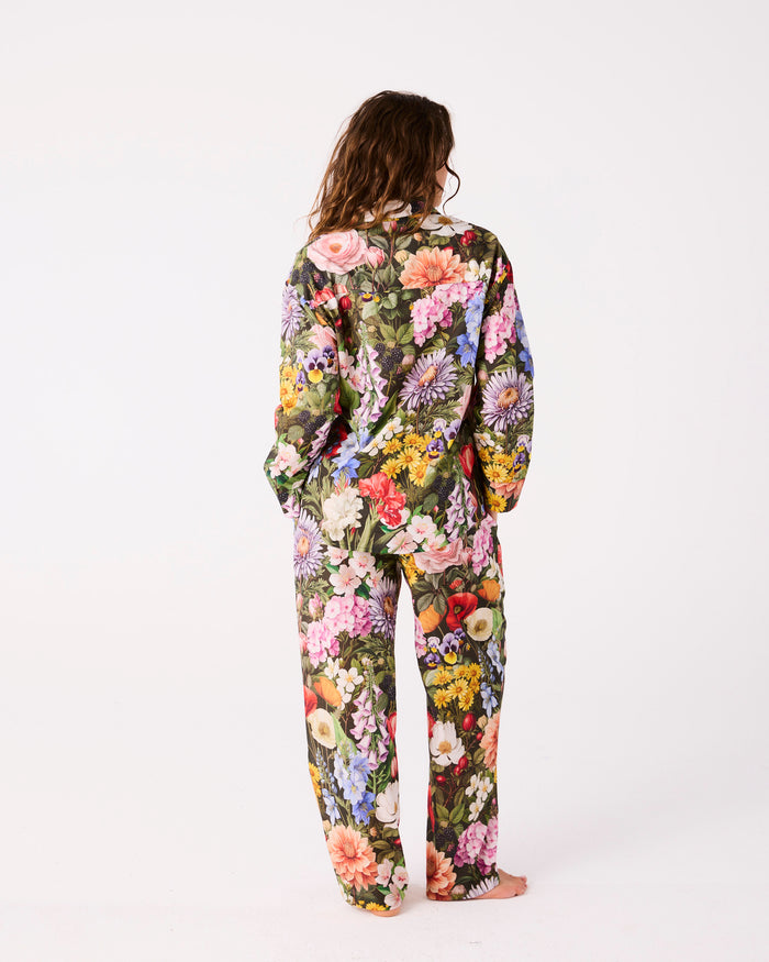 Person wearing a floral pyjama shirt and pants on a white background
