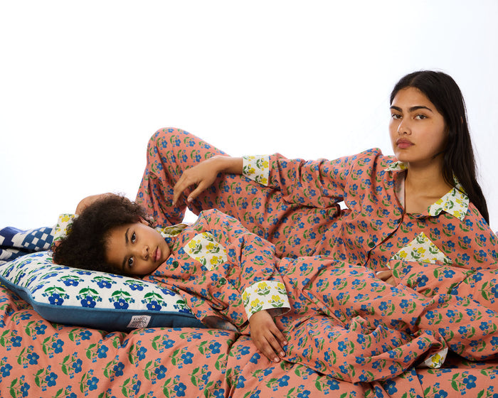 Two people wearing matching floral pajamas on a white background