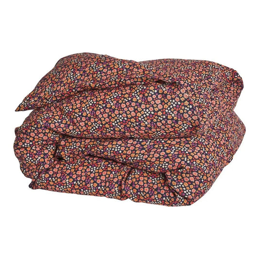 A folded linen quilt cover with a hand-drawn floral design including navy base and mix of colours in red, pink, purple, and peach.