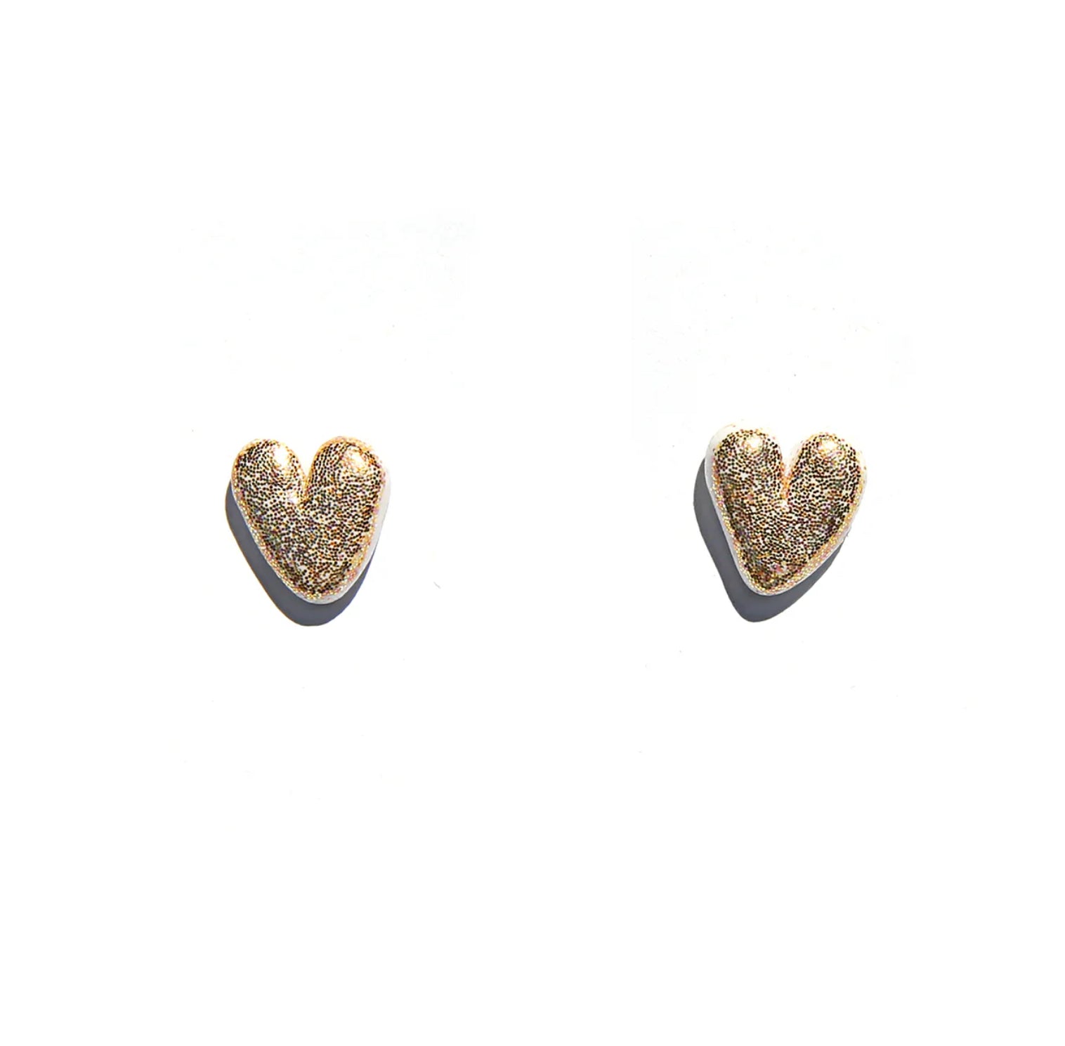 Heart shaped earrings with gold glitter, white background.