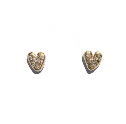 Heart shaped earrings with gold glitter, white background.