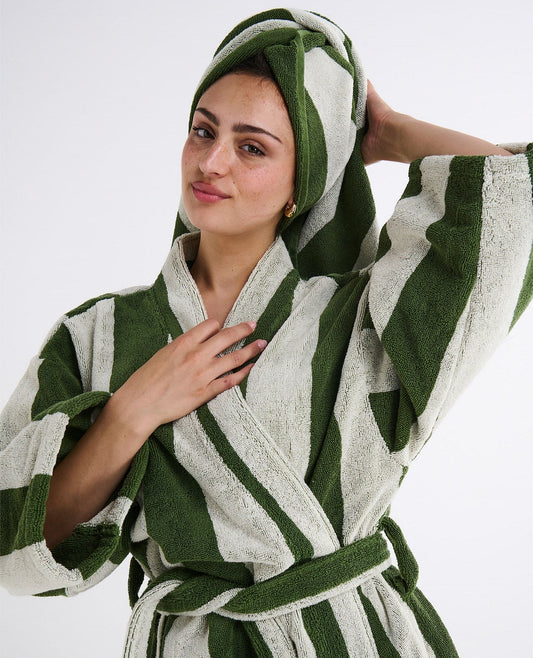 Woman wearing a green and white striped robe on a white background
