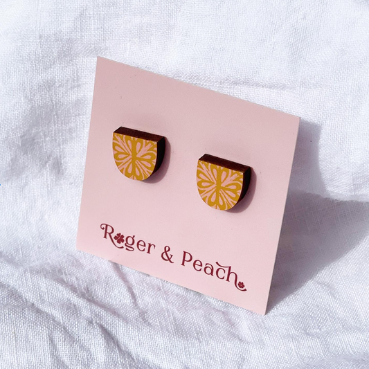 Wooden mustard and pink pattern arch shape earrings on a 'Roger & Peach' branded card against a white background