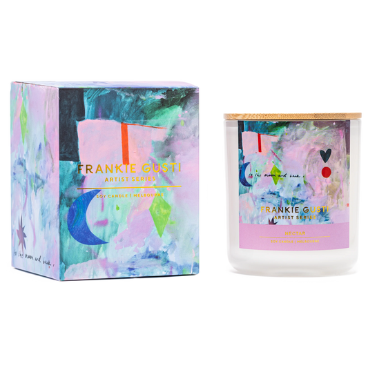 Candle jar sat next to box with blue pink red abstract artwork