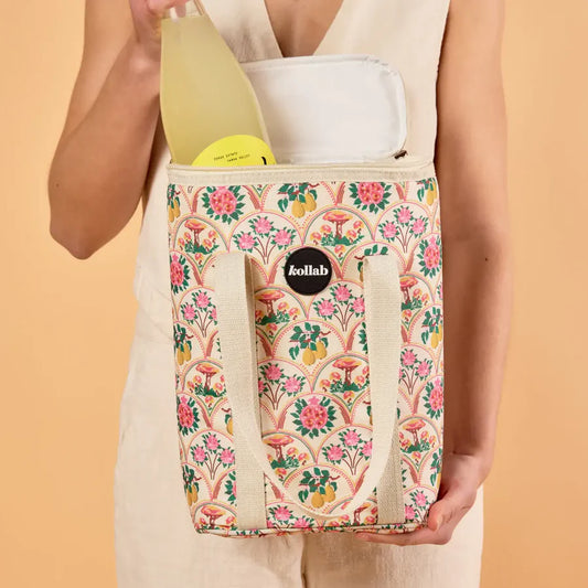 Person holding a floral-patterned bag with a visible brand logo against a beige background