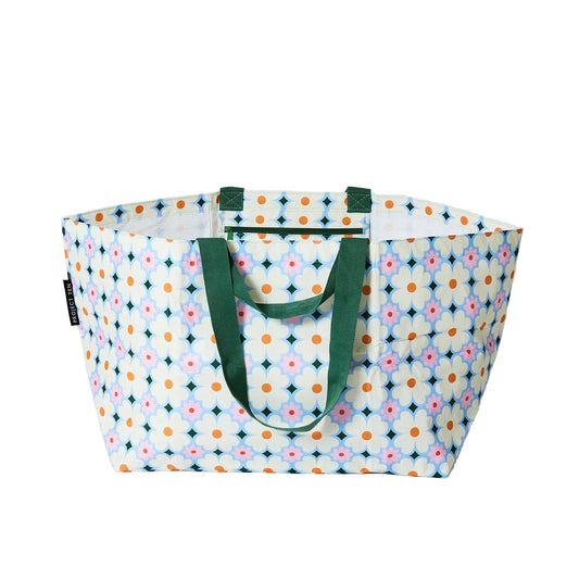 Multicolored patterned tote bag with green handles on a white background