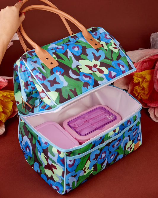 Colorful floral-patterned cooler bag with pink containers on a brown background