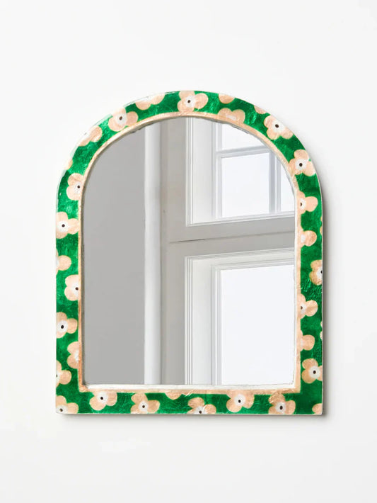 Decorative mirror with a green floral frame on a white background