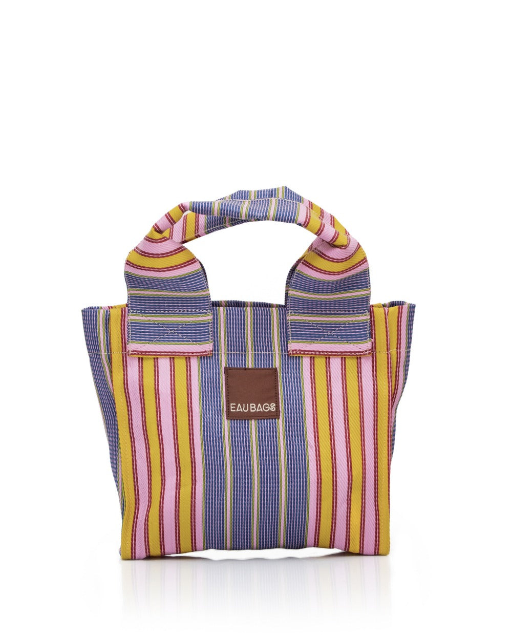 Stripe bag with short double handles sits with white background. Bag features stripe pattern and pink, red, blue, green and yellow colours. 