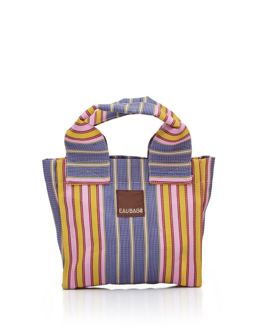 Stripe bag with short double handles sits with white background. Bag features stripe pattern and pink, red, blue, green and yellow colours. 