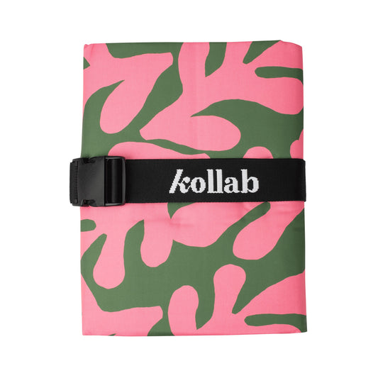 Picnic mat with green and pink pattern sits on white background.