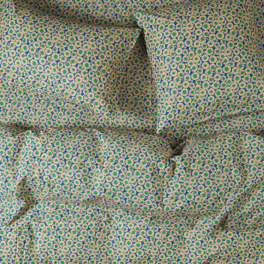 Floral patterned fabric with peach/white flowers, green centre on a blue background