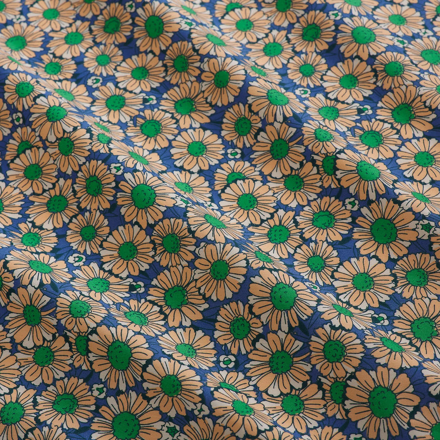 Pattern of peach and white flowers with green centers on a blue background