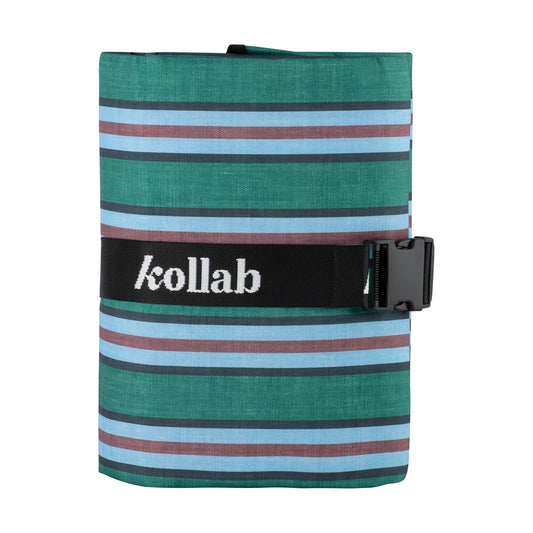 A rolled-up striped fabric item, likely a towel or blanket, featuring horizontal bands of green, light blue, dark gray, and muted red. It is secured with a black elastic strap across the middle that has the white text 'collab' on it, set against a plain white background.