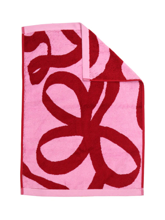 Pink towel with red abstract pattern on a white background