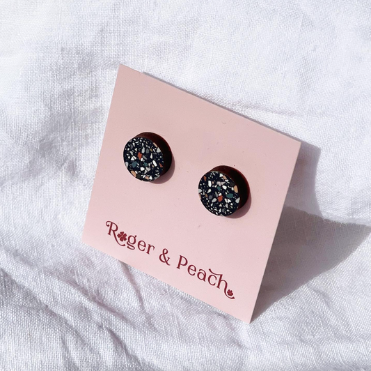 Black granite pattern stud earrings on a 'Roger & Peach' branded card against a white fabric background.