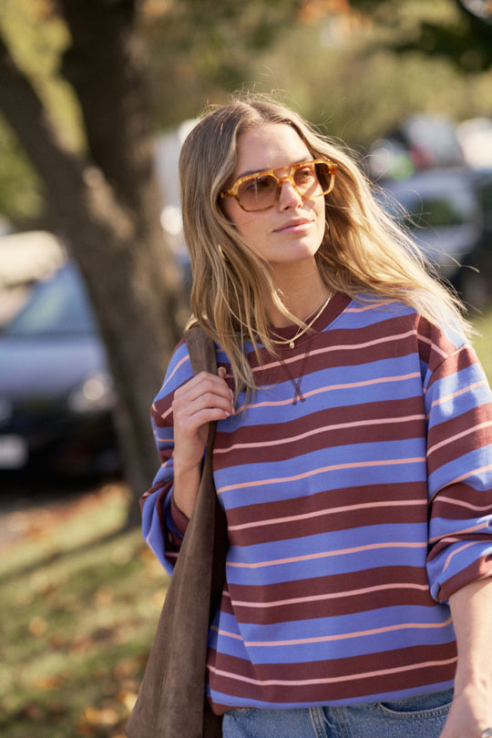 Woman wearing a striped sweater and sunglasses outdoors