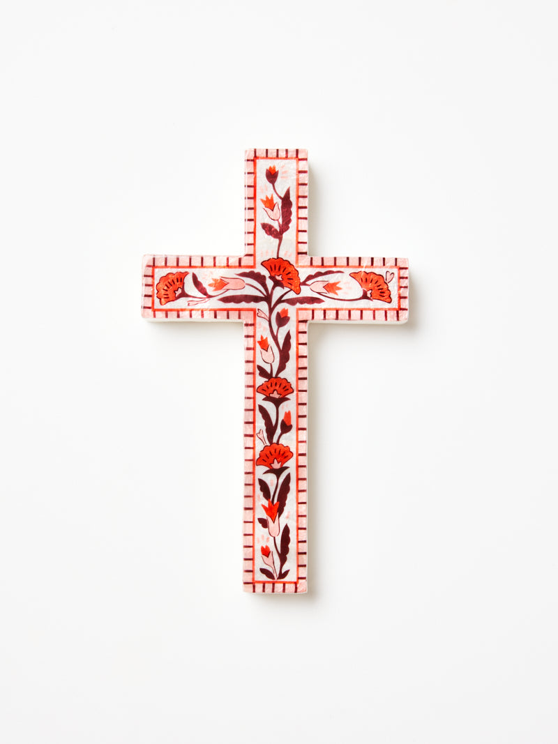 Shell wall art in shape of the cross with pink, red and burgundy floral details. 