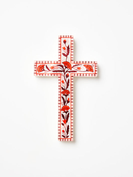Shell wall art in shape of the cross with pink, red and burgundy floral details. 