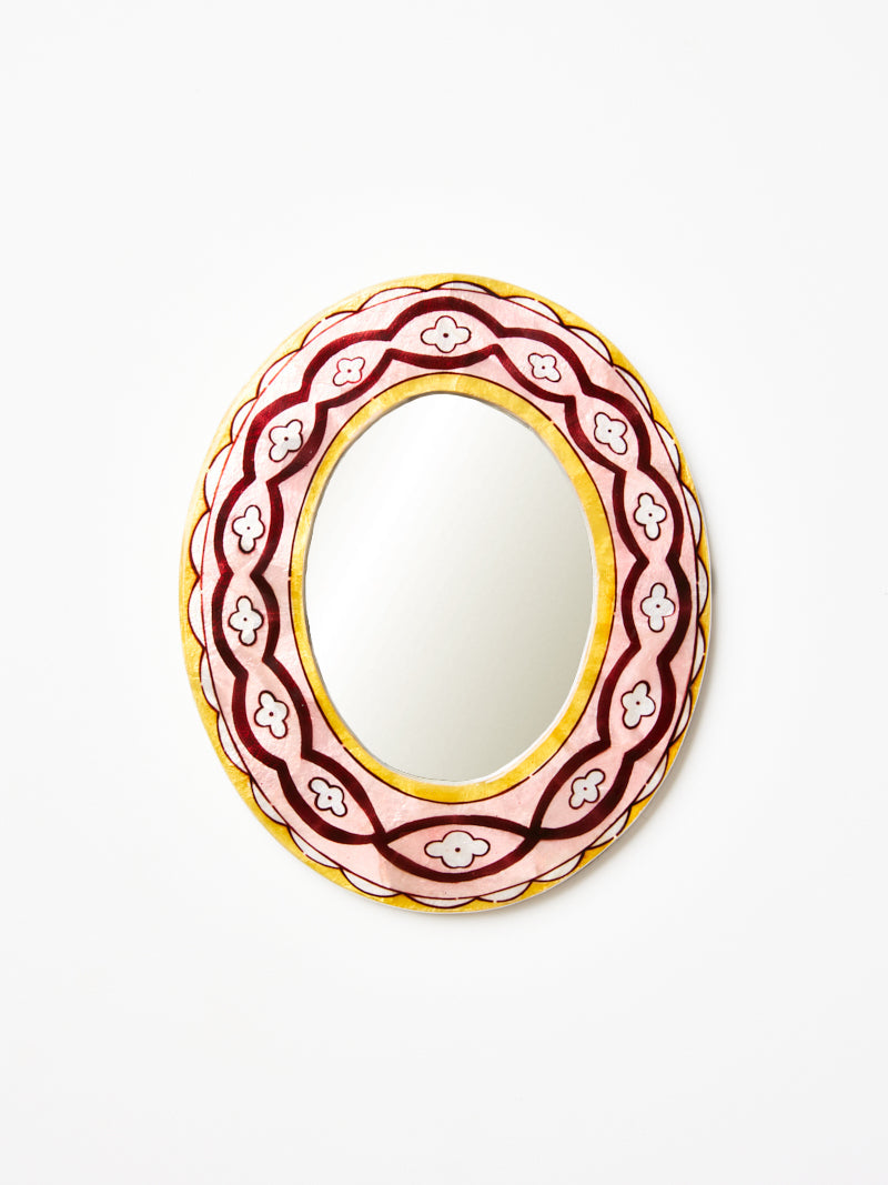 Decorative oval mirror with floral pattern on a white background